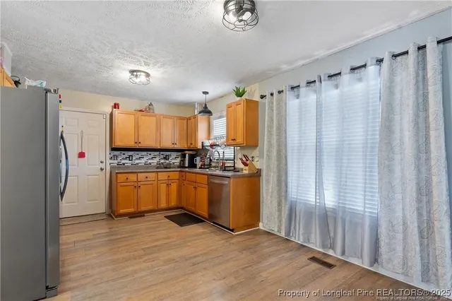 a kitchen with granite countertop stainless steel appliances a counter top space and cabinets