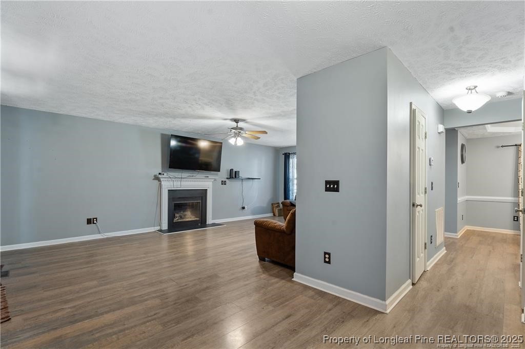 717 Lenoir Drive Spring Lake, NC 28390 - Photo 14 of 47 a view of a livingroom with a fireplace a ceiling fan and wooden floor