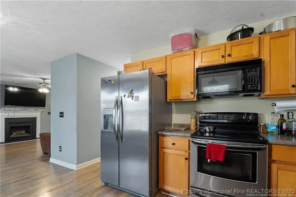 a kitchen with stainless steel appliances granite countertop a stove top oven a refrigerator and a microwave