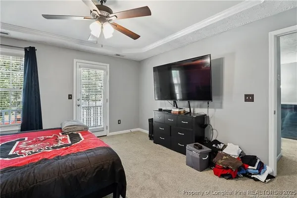 a bedroom with a bed and a flat tv screen on dresser
