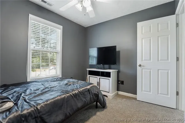 a bedroom with a bed and a ceiling fan