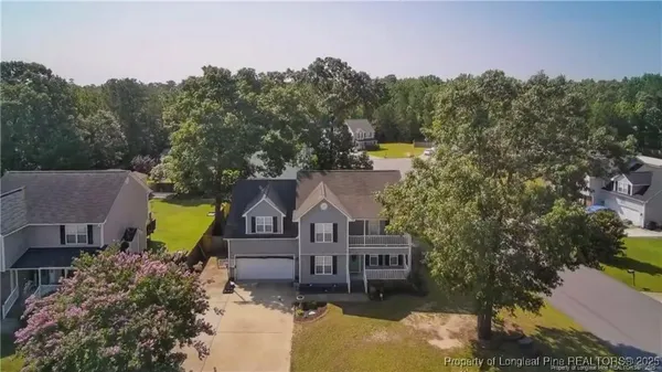 a aerial view of a house with a big yard and large trees
