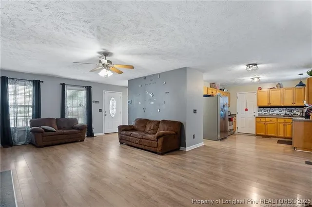 a kitchen with granite countertop a refrigerator a sink and dishwasher wooden cabinets