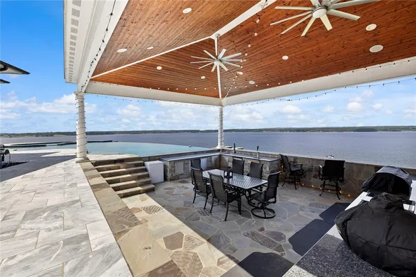 a view of swimming pool with lawn chairs and plants