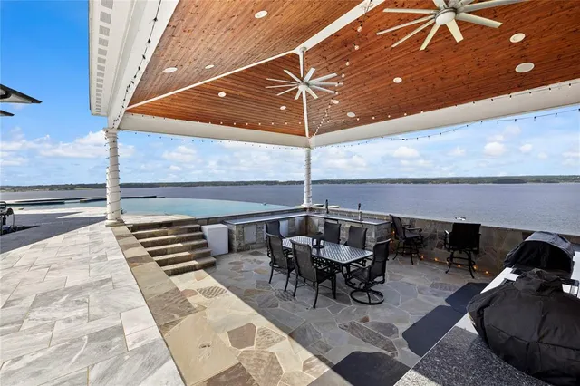 a view of swimming pool with lawn chairs and plants