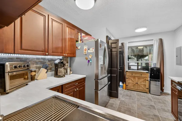 a kitchen with stainless steel appliances granite countertop a refrigerator and a stove top oven