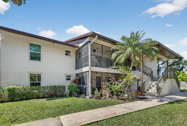 a front view of house and yard with beautiful flowers and green space