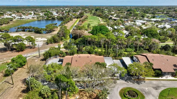an aerial view of a house with a yard and lake view