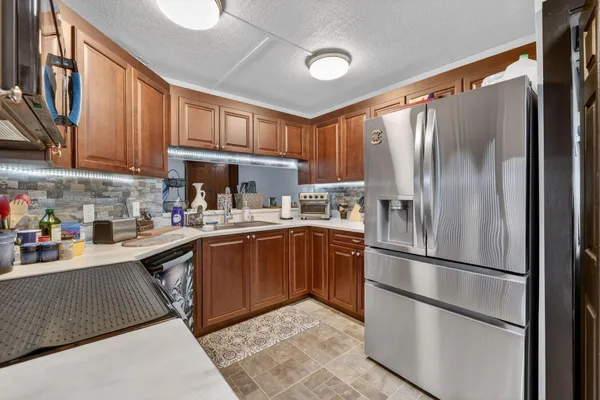 a kitchen with stainless steel appliances granite countertop a refrigerator sink and cabinets
