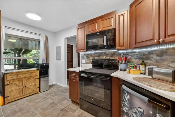 a kitchen with stainless steel appliances granite countertop a stove a sink and a microwave