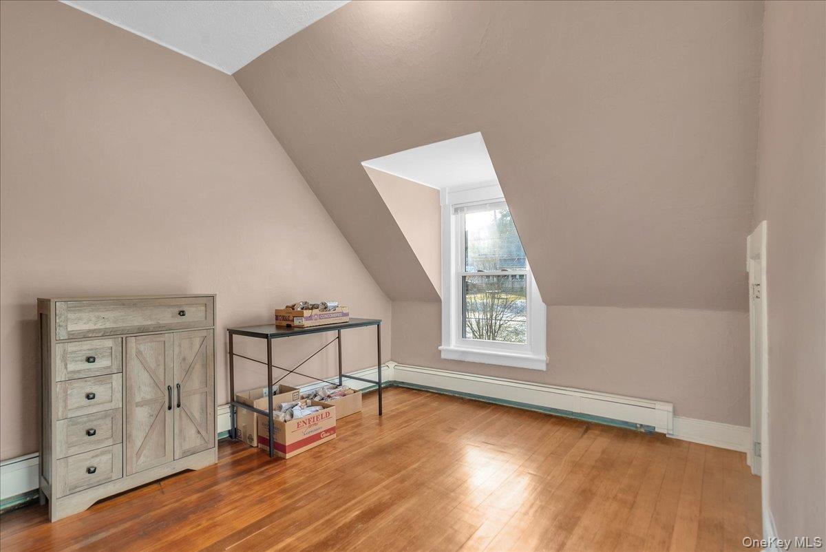 10 Spartan Place, Unit B Tuxedo Park, NY 10987 - Photo 12 of 27 an empty room with windows and wooden floor