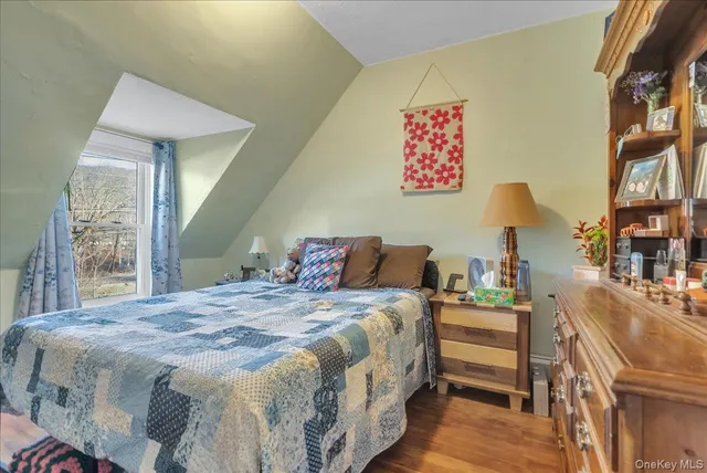 a bedroom with a bed and a lamp with the wooden floor