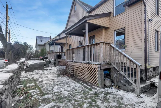 a view of a house with wooden deck and furniture