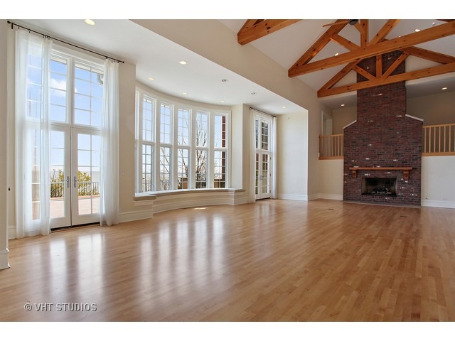 1203 Whitebridge Hill Road Winnetka, IL 60093 - Photo 4 of 24 a view of an empty room with wooden floor and a window