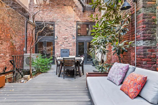 a view of a patio with dining table and chairs with wooden floor and fence
