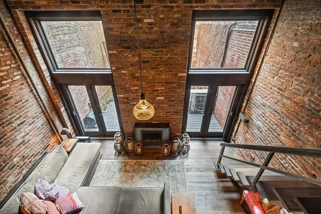 a view of a patio with table and chairs potted plants and large tree