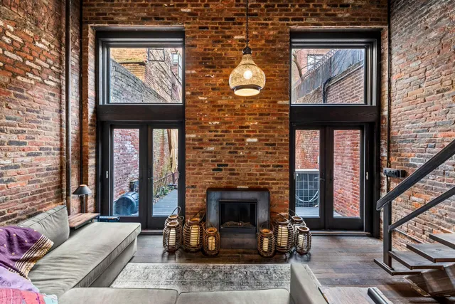 a living room with furniture a fireplace and windows