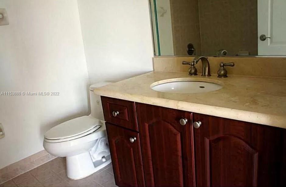 120 South Douglas Road, Unit 306 Miami, FL 33134 - Photo 14 of 17 a bathroom with a granite countertop sink and a toilet