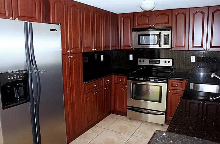 120 South Douglas Road, Unit 306 Miami, FL 33134 - Photo 7 of 17 a kitchen with granite countertop a refrigerator stove and microwave