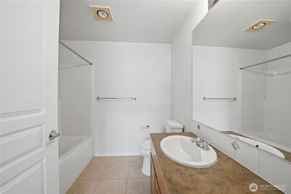 a bathroom with a tub sink and mirror