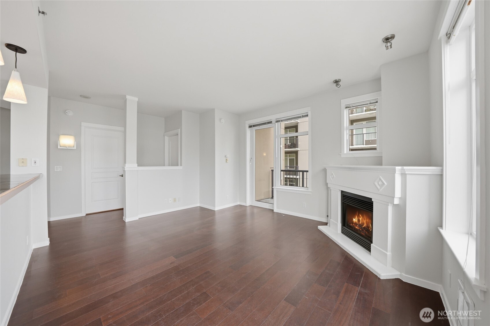 2801 1st Avenue, Unit 504 Seattle, WA 98121 - Photo 7 of 34 an empty room with wooden floor fireplace and windows