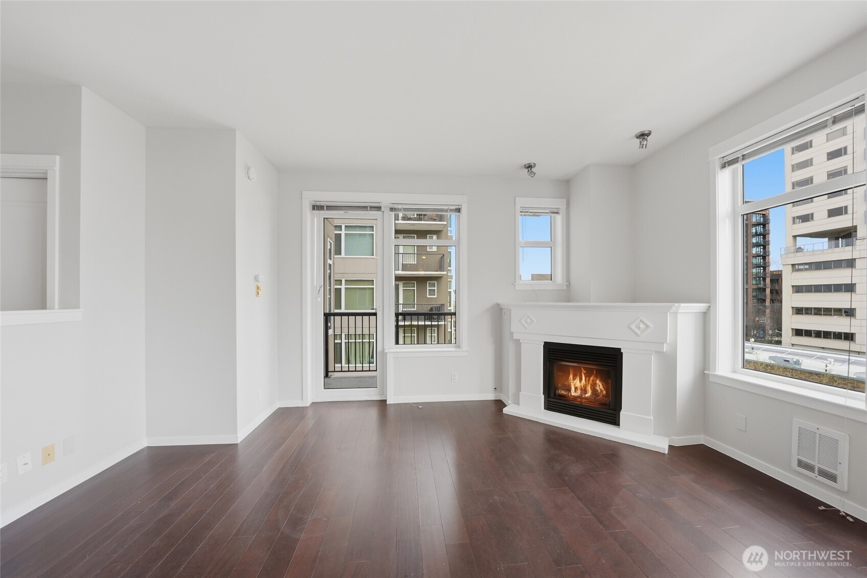 2801 1st Avenue, Unit 504 Seattle, WA 98121 - Photo 8 of 34 a view of an empty room with wooden floor fireplace and a window