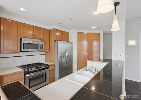 a kitchen with stainless steel appliances a refrigerator a stove and a sink