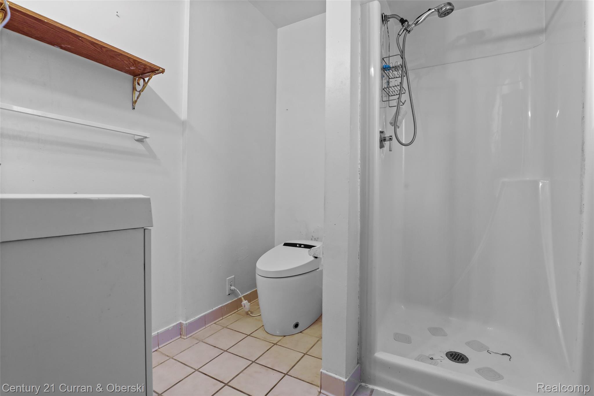 704 Inkster Road Dearborn Heights, MI 48127 - Photo 21 of 32 Walk-in shower with a mounted showerhead, tiled flooring, and a wall-mounted vanity