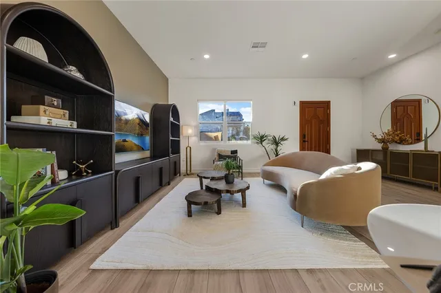 a living room with furniture a dining table and wooden floor