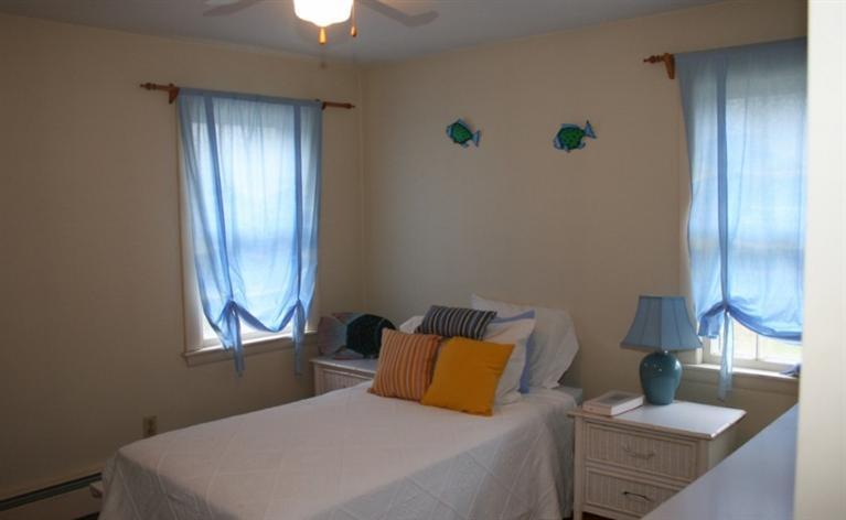 411 Lower County Road Harwich Port, MA 02646 - Photo 18 of 32 a bedroom with a bed and a lamp on table