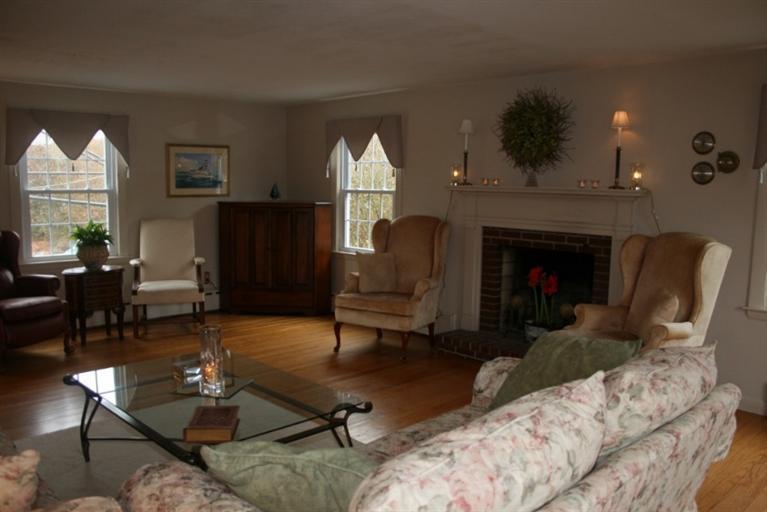 411 Lower County Road Harwich Port, MA 02646 - Photo 8 of 32 a living room with furniture a fireplace and a large mirror with wooden floor