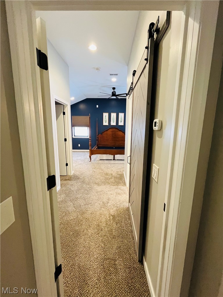 13655 Spring Street Burton, OH 44021 - Photo 40 of 48 Corridor featuring light carpet, lofted ceiling, and a barn door