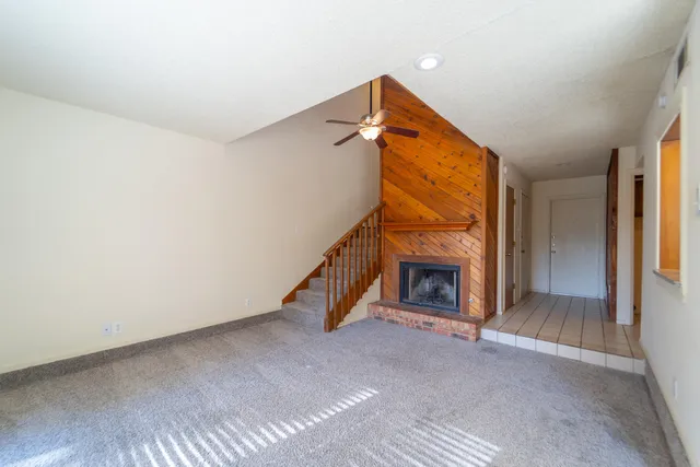 a view of an empty room with fireplace and a window