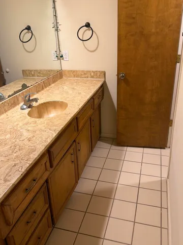 a bathroom with a granite countertop sink and a mirror