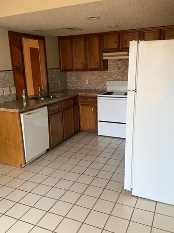 a kitchen with stainless steel appliances granite countertop a refrigerator sink and cabinets