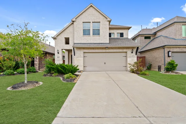 a front view of a house with a yard and a garage