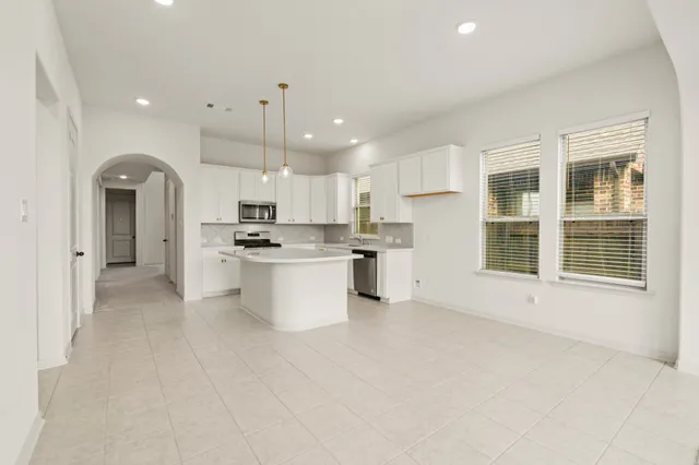 a open kitchen with white cabinets and white appliances