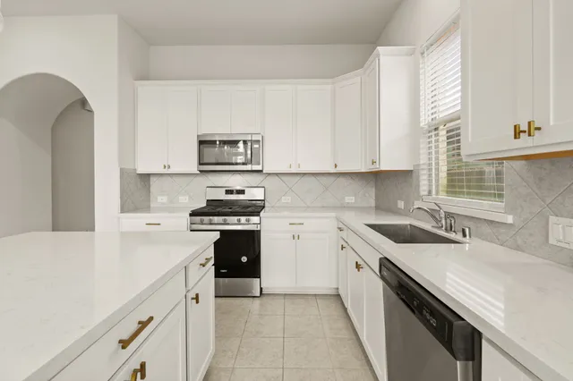 a kitchen with stainless steel appliances granite countertop a sink and a stove