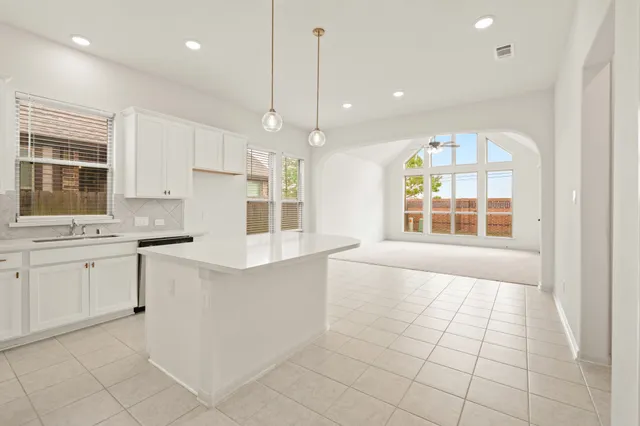 a large white kitchen with cabinets and a stove