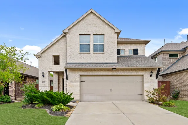 a front view of a house with a yard and garage