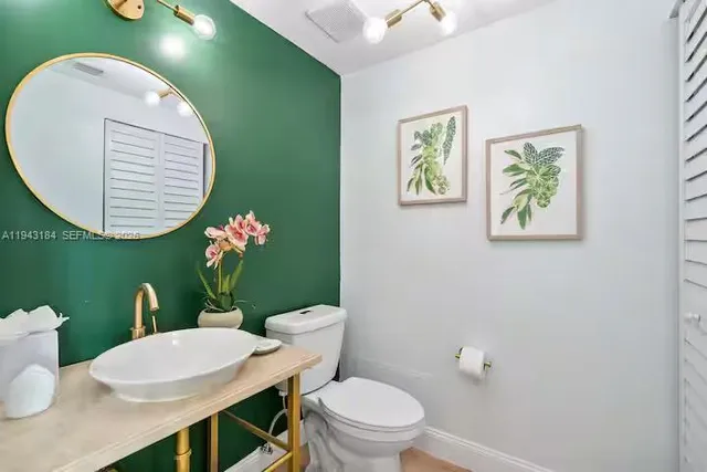 a bathroom with a toilet a sink and mirror