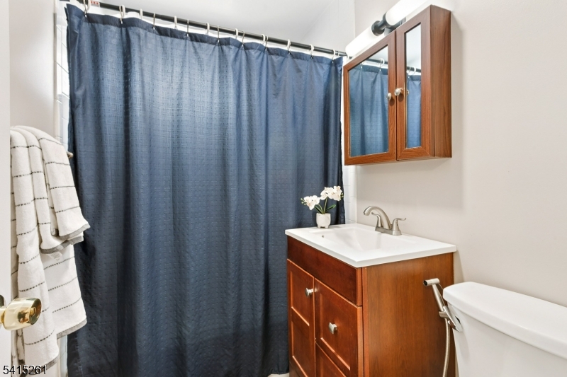 32 Glenville Road Edison, NJ 08817 - Photo 22 of 25 a bathroom with a sink a toilet and shower curtain