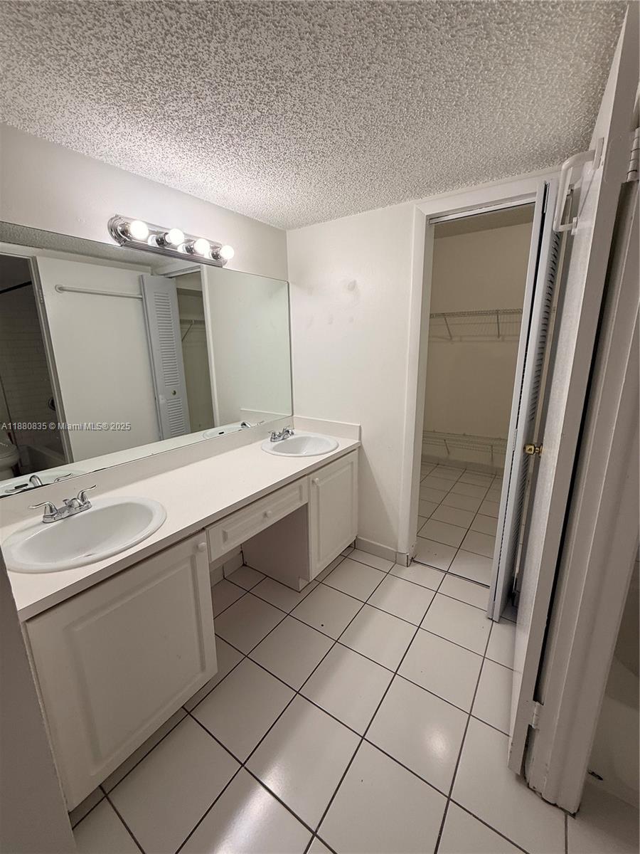 6300 Southwest 138th Court, Unit 102 Miami, FL 33183 - Photo 12 of 17 a bathroom with a sink and a mirror
