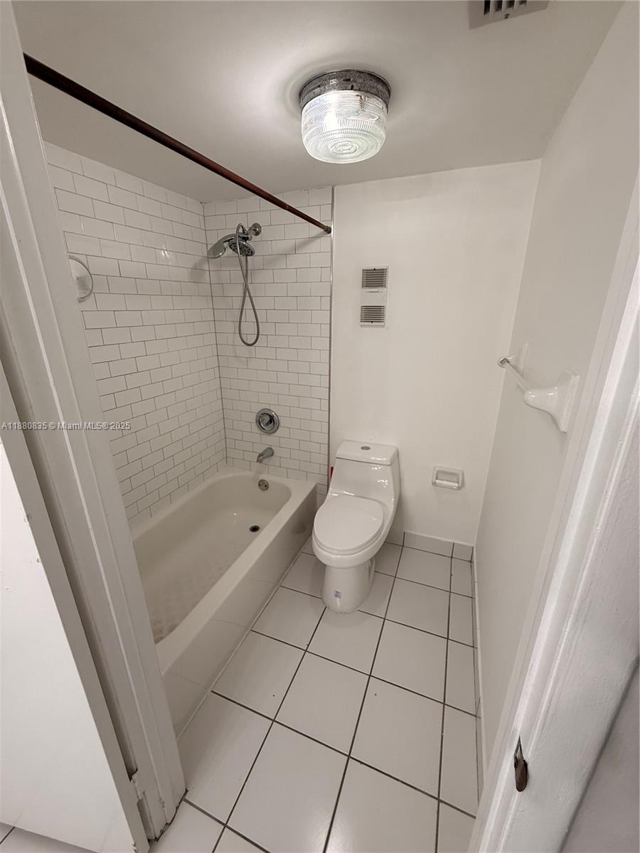 6300 Southwest 138th Court, Unit 102 Miami, FL 33183 - Photo 15 of 17 a bathroom with a granite countertop bathtub shower and toilet