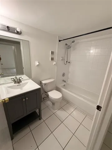 a bathroom with a sink and mirror with bathtub
