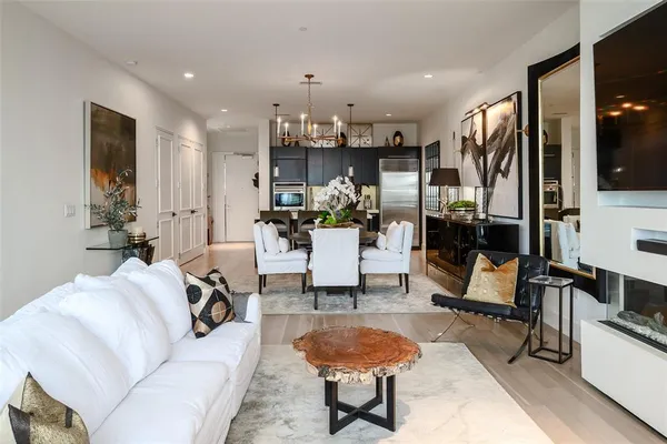 a living room with furniture and a dining table with kitchen view