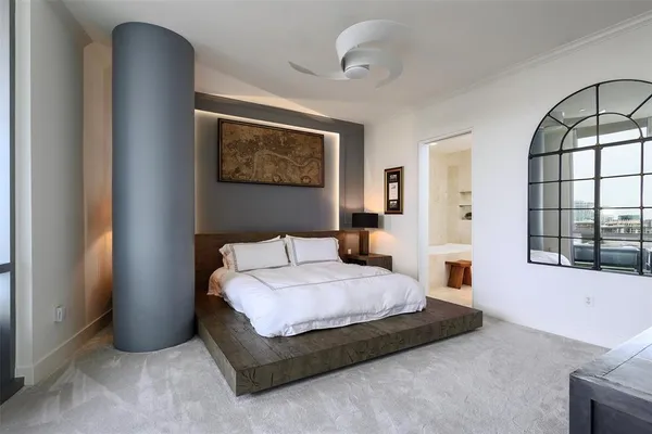 a bedroom with a bed mirror and window