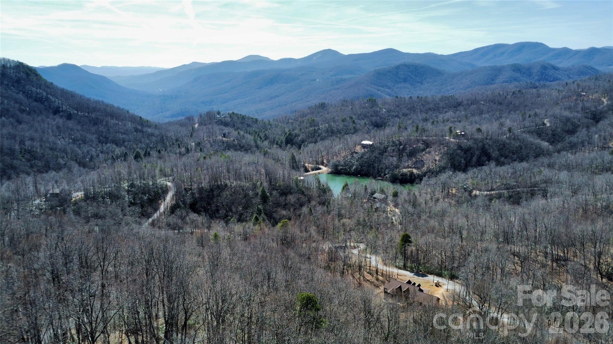 965 Wolf Pen Road Old Fort, NC 28762 - Photo 2 of 26 a view of a lush green hillside and a houses