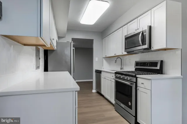 a kitchen with stainless steel appliances a stove microwave and refrigerator