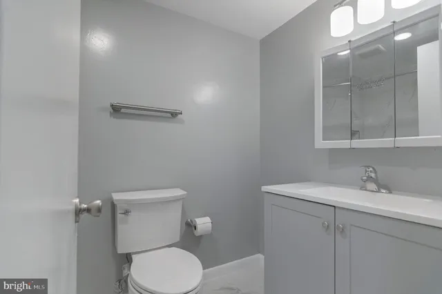 a bathroom with a toilet a sink and mirror